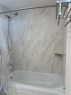 a bathroom with a shower and a bath tub