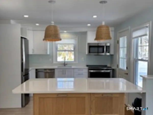 a kitchen with kitchen island a stove and a sink
