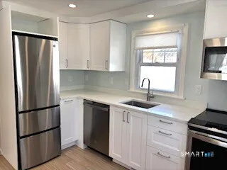 a kitchen with appliances a sink and a window