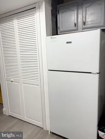 a view of a refrigerator in kitchen and a window