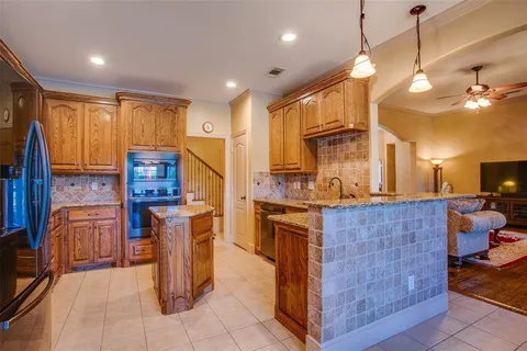 a kitchen with stainless steel appliances granite countertop a stove a sink dishwasher and a refrigerator