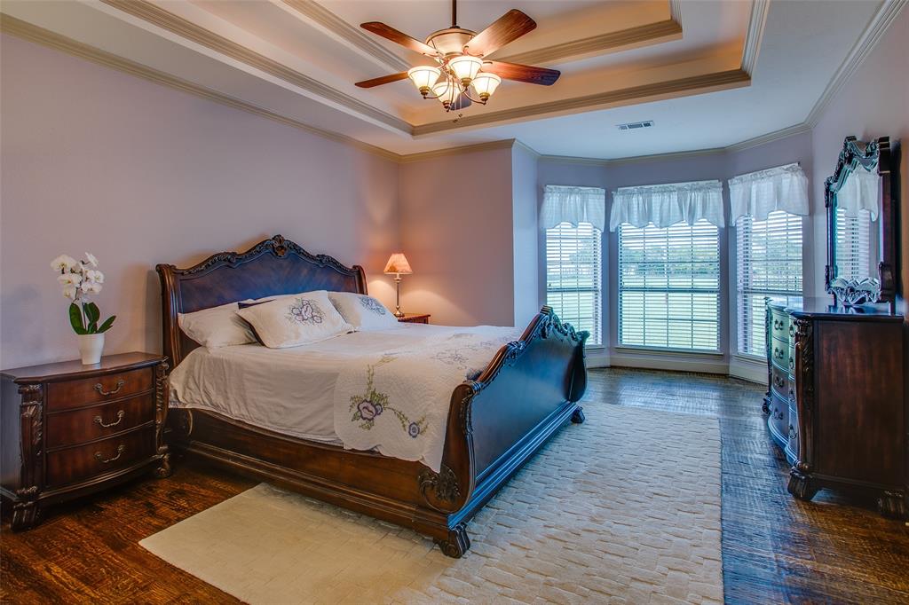 10044 Dennehy Drive Talty, TX 75126 - Photo 19 of 40 a bedroom with a bed and a chandelier
