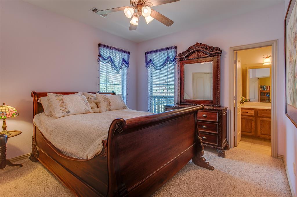10044 Dennehy Drive Talty, TX 75126 - Photo 23 of 40 a bedroom with a bed and a large mirror on dresser