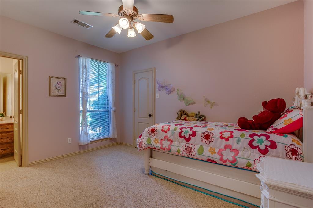 10044 Dennehy Drive Talty, TX 75126 - Photo 25 of 40 a bedroom with a bed and a chandelier