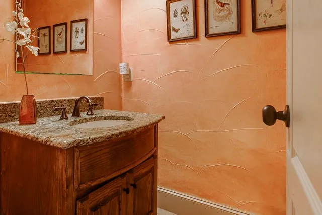 a bathroom with a granite countertop sink and a mirror