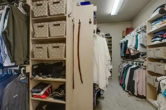 a view of walk in closet with clothes