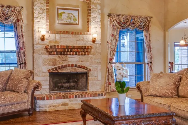 a living room with furniture a fireplace and a potted plant