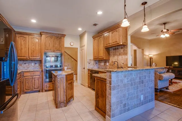 a kitchen with stainless steel appliances granite countertop a stove a sink dishwasher and a refrigerator