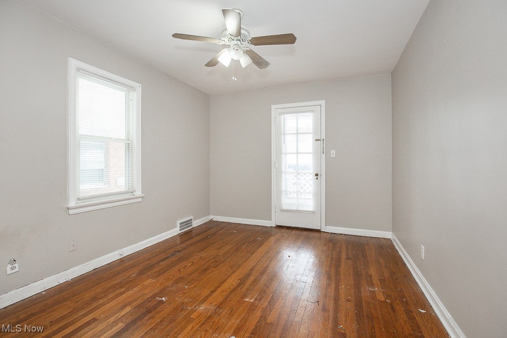 13545 Cedar Road Cleveland, OH 44118 - Photo 12 of 41 Unfurnished room featuring dark wood-type flooring, visible vents, baseboards, and a ceiling fan