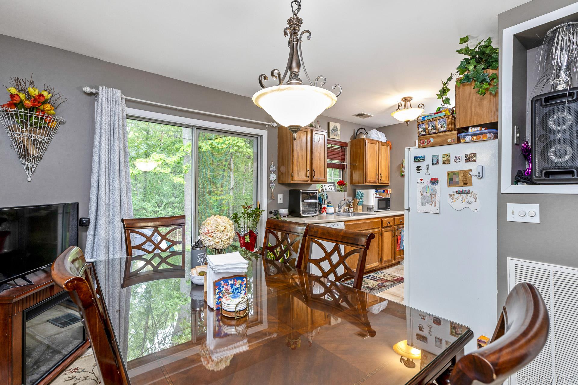 17 Stone Commons Yaphank, NY 11980 - Photo 14 of 31 Dining area featuring a sliding glass door, overhead chandelier, and wood-finish dining table