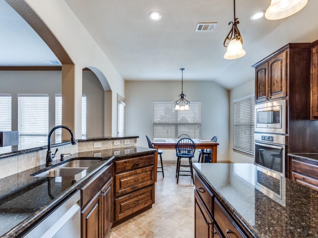 519 Gene Autry Lane Murphy, TX 75094 - Photo 11 of 25 Kitchen with dark stone counters, pendant lighting, dark brown cabinets, appliances with stainless steel finishes, and recessed lighting