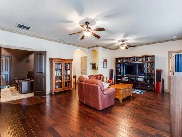 a living room with furniture flat screen tv and wooden floor