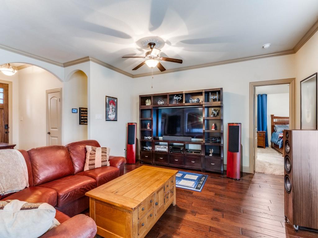 519 Gene Autry Lane Murphy, TX 75094 - Photo 4 of 25 Living room with dark wood-style floors, crown molding, ceiling fan, and arched walkways