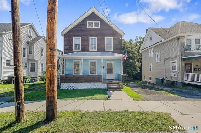a front view of a house with a yard and potted plants