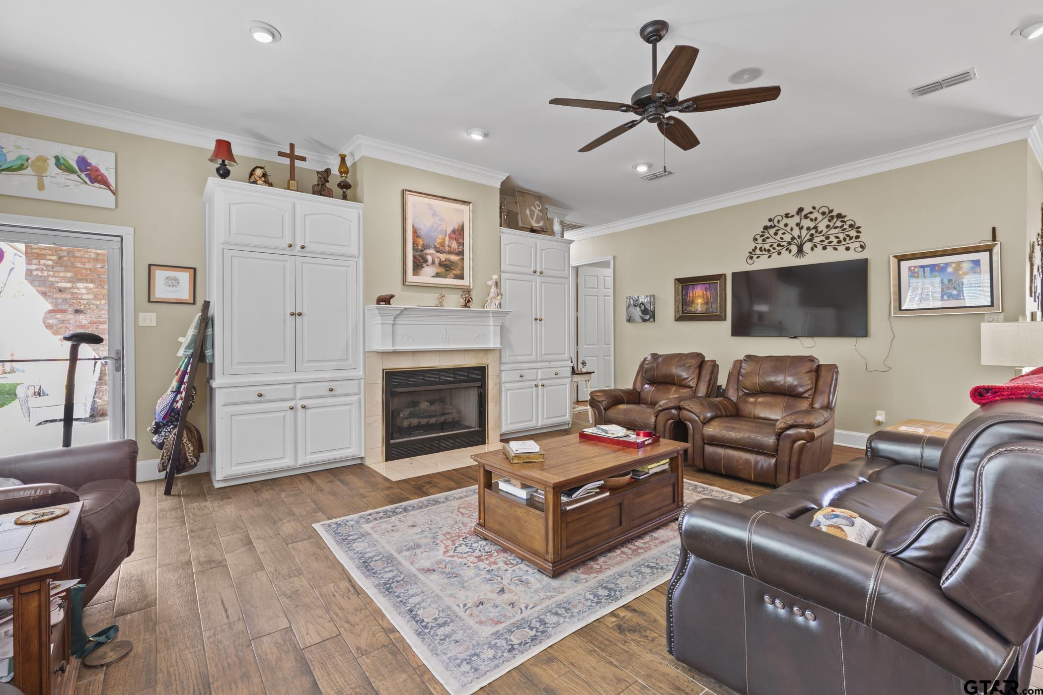 2315 Homestead Lane Tyler, TX 75701 - Photo 11 of 20 a living room with furniture a fireplace and a flat screen tv