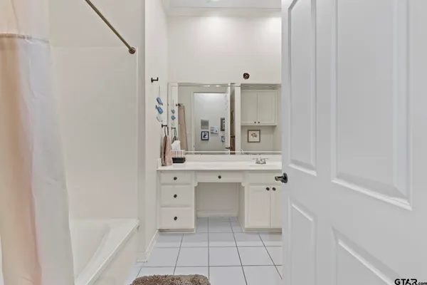 a bathroom with a bathtub sink vanity and mirror