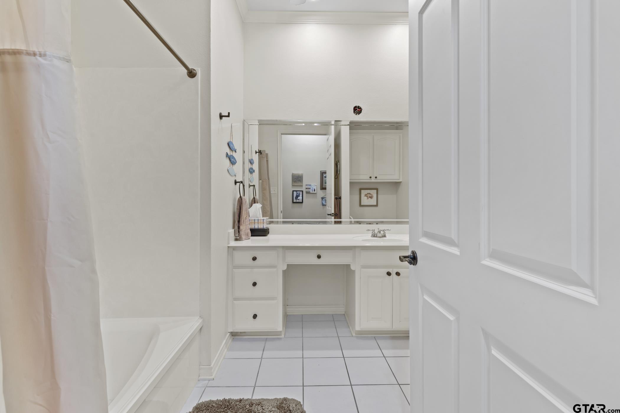 2315 Homestead Lane Tyler, TX 75701 - Photo 15 of 20 a bathroom with a bathtub sink vanity and mirror