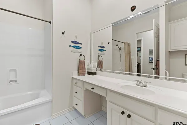 a bathroom with a tub sink and mirror