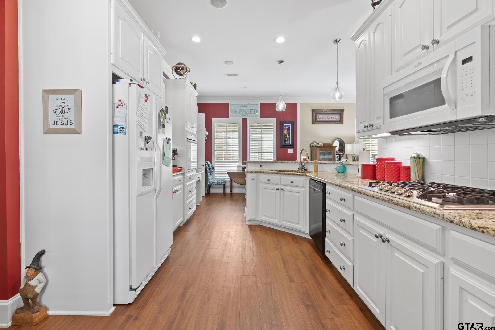 2315 Homestead Lane Tyler, TX 75701 - Photo 8 of 20 a kitchen with stainless steel appliances a sink dishwasher stove refrigerator and cabinets with wooden floor