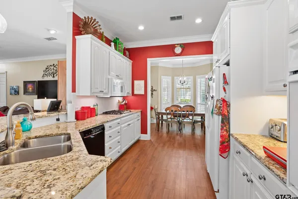 a kitchen with kitchen island granite countertop wooden cabinets and stainless steel appliances