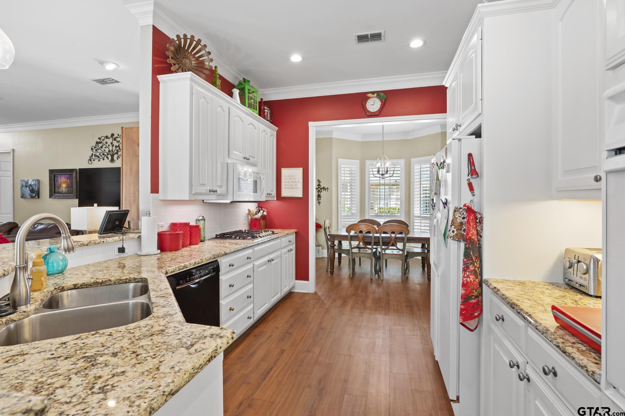 2315 Homestead Lane Tyler, TX 75701 - Photo 9 of 20 a kitchen with kitchen island granite countertop wooden cabinets and stainless steel appliances