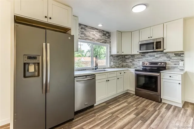 a kitchen with stainless steel appliances a refrigerator sink and microwave