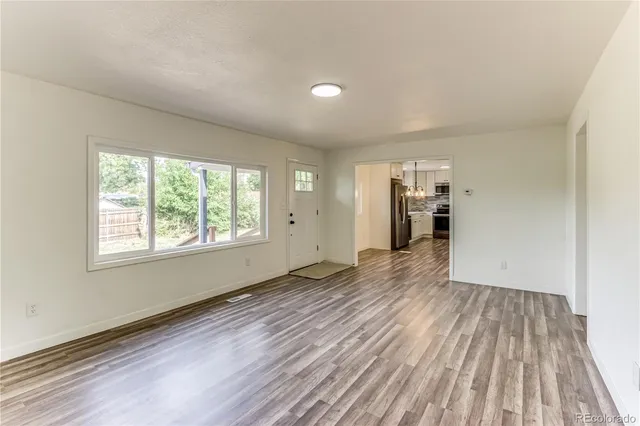 a view of empty room with wooden floor and window