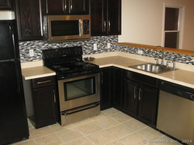 a kitchen with granite countertop stove top oven microwave and sink