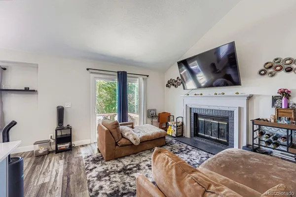 a living room with furniture a fireplace and a flat screen tv