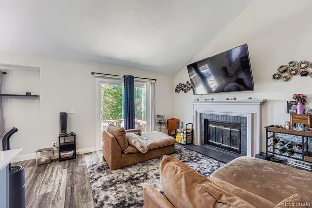 a living room with furniture a fireplace and a flat screen tv