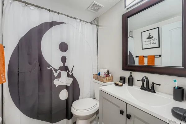 a bathroom with a sink mirror vanity and toilet
