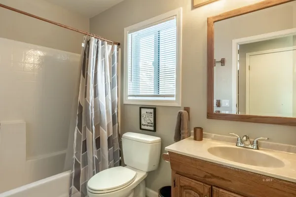 a bathroom with a sink toilet a mirror and shower