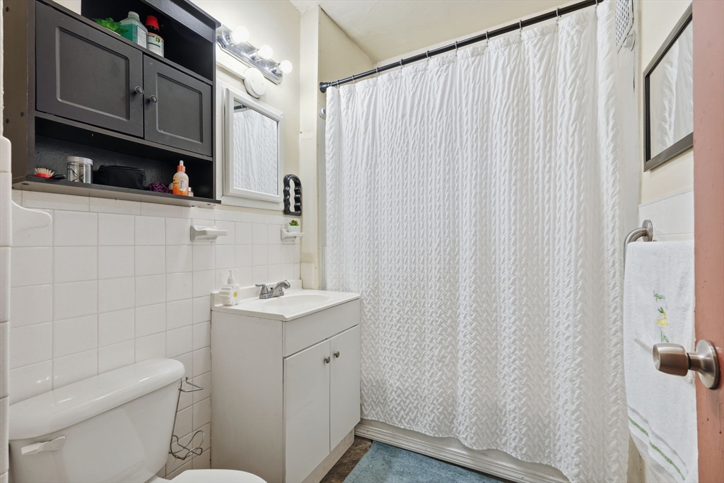 50-52 Maynard Street Springfield, MA 01109 - Photo 28 of 33 a bathroom with a sink a toilet and shower curtain