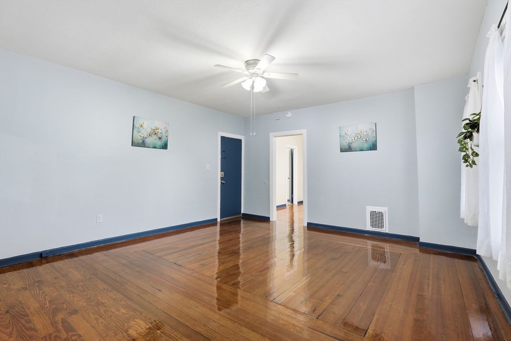 50-52 Maynard Street Springfield, MA 01109 - Photo 9 of 33 a view of an empty room with wooden floor and a ceiling fan