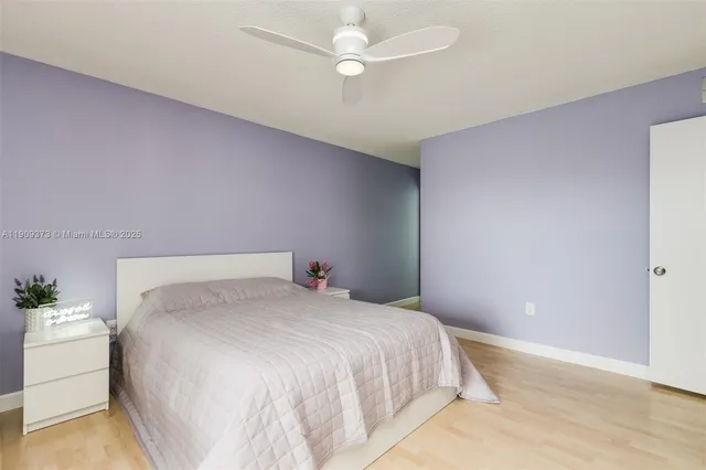 a bedroom with a bed chandelier and a window