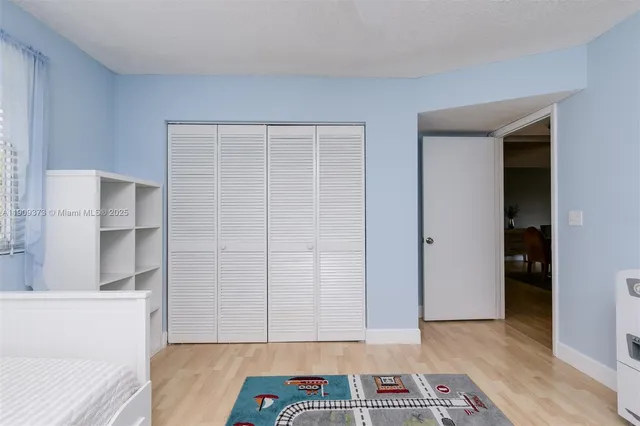 a view of room with walk in closet and wooden floor