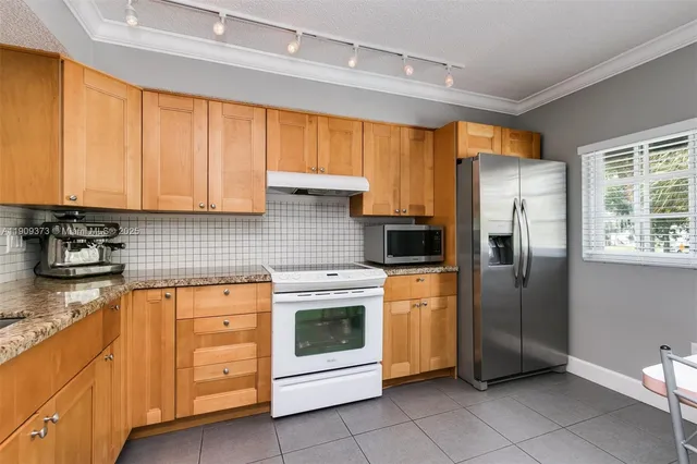 a kitchen with stainless steel appliances a stove sink and refrigerator