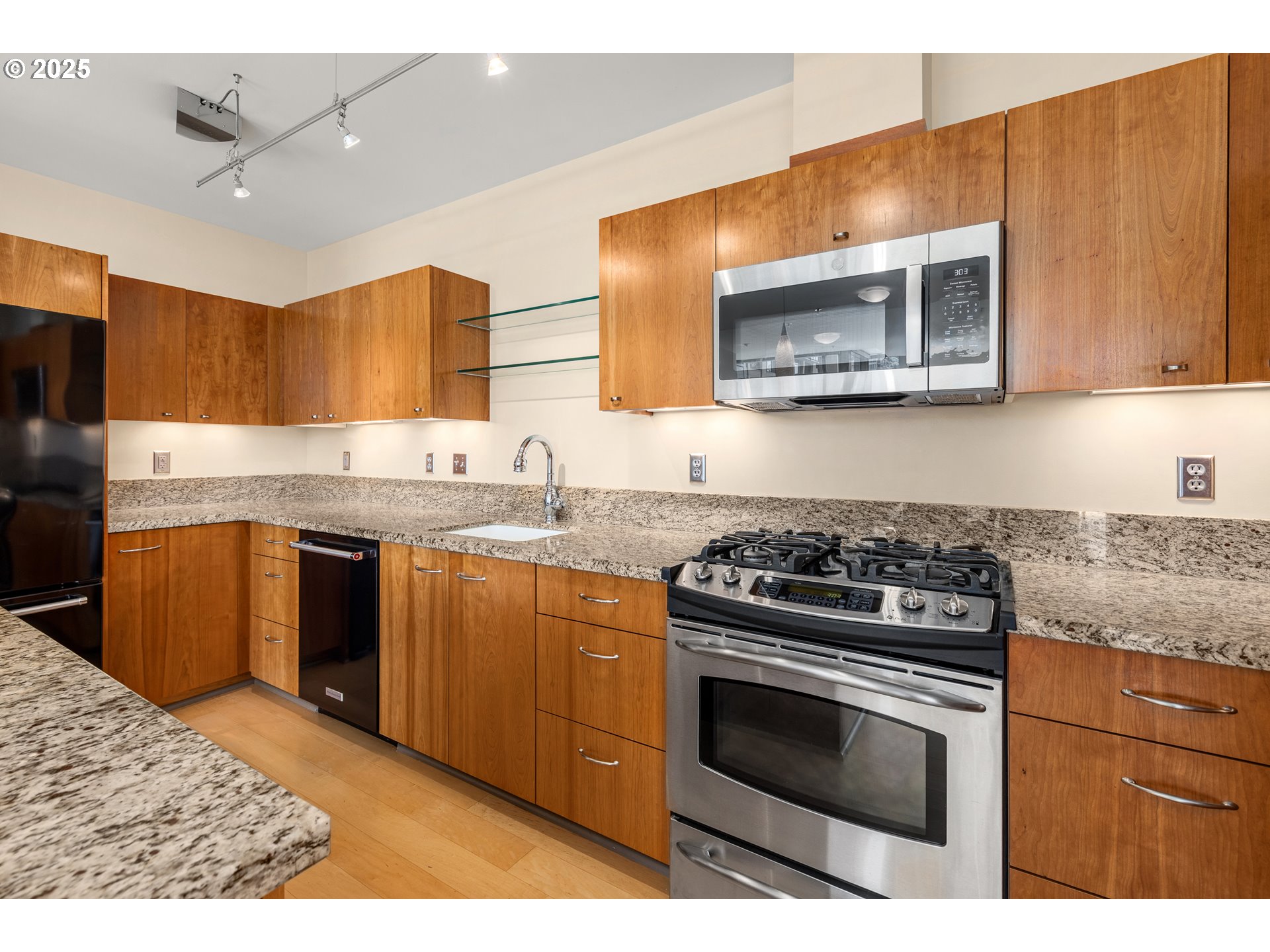 1221 Southwest 10th Avenue, Unit 505 Portland, OR 97205 - Photo 18 of 41 a kitchen with stainless steel appliances granite countertop a stove a sink and a microwave