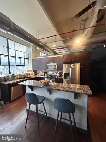 a kitchen with a table chairs and wooden floor