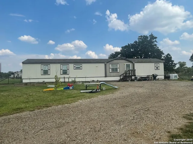 a front view of a house with a garden and trees