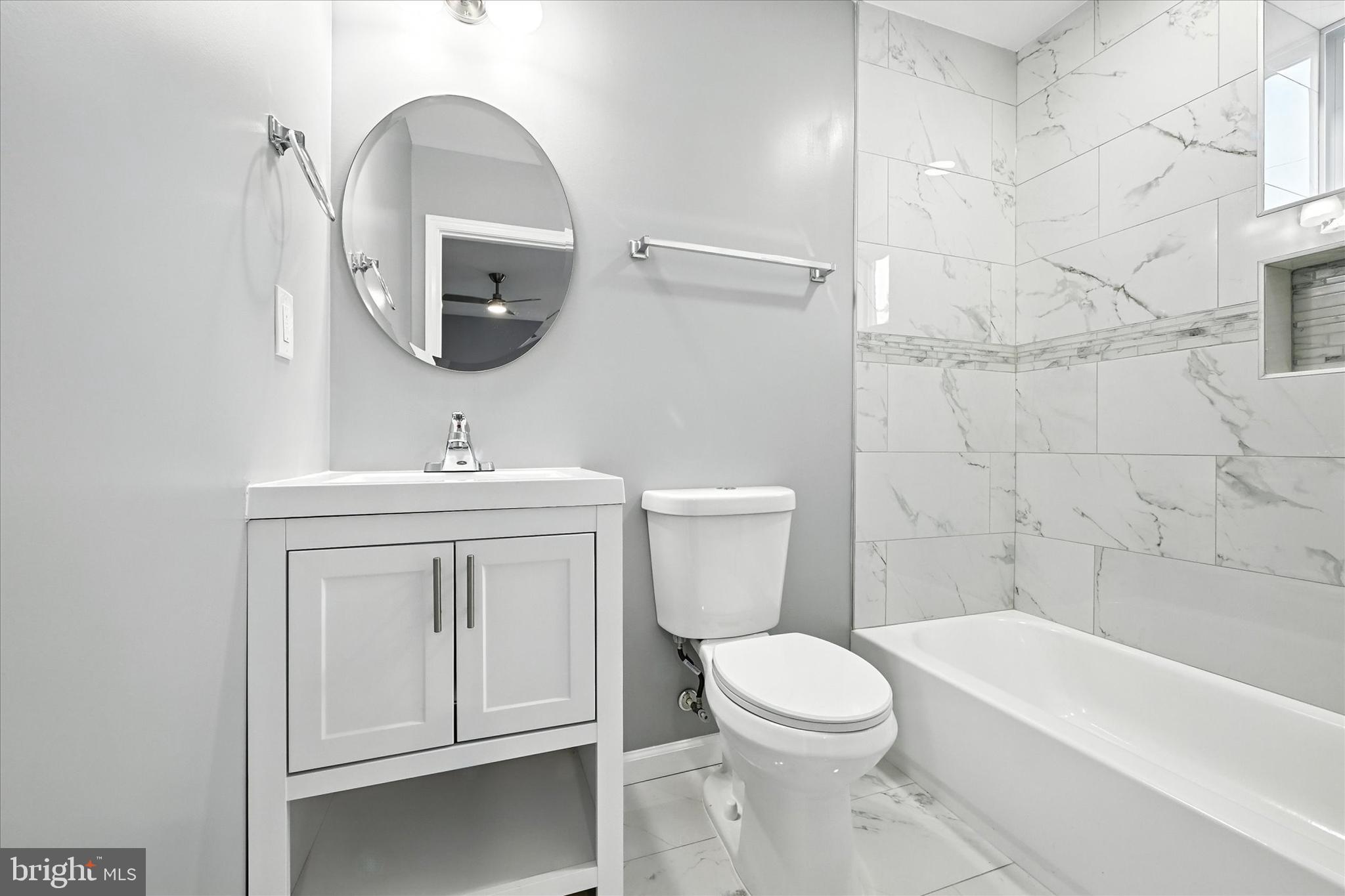 1118 Weldon Avenue Baltimore, MD 21211 - Photo 17 of 27 a bathroom with a toilet a sink a mirror and bathtub