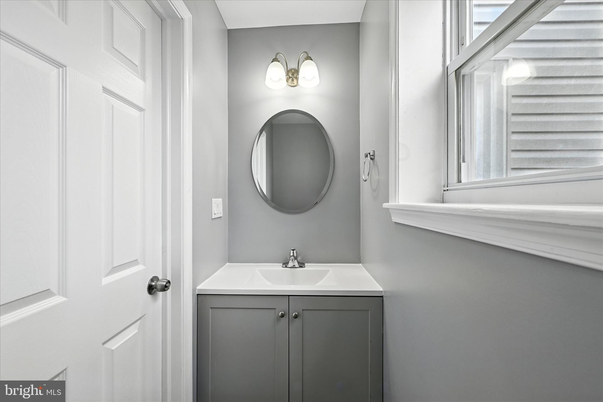 1118 Weldon Avenue Baltimore, MD 21211 - Photo 20 of 27 a bathroom with a sink and a mirror
