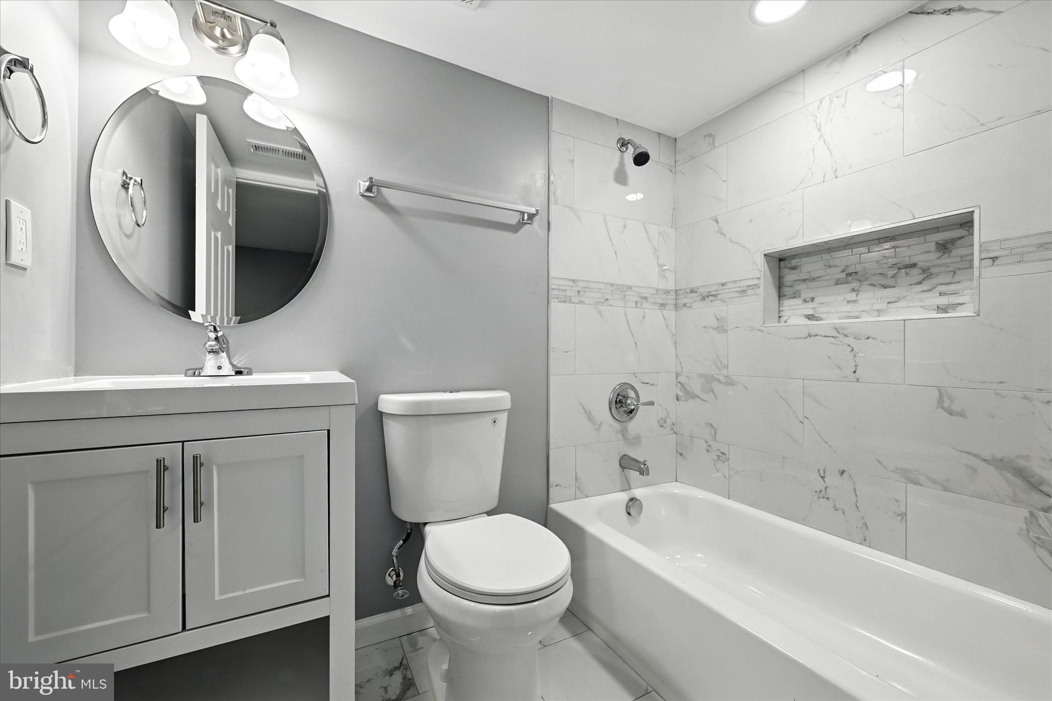 1118 Weldon Avenue Baltimore, MD 21211 - Photo 23 of 27 a bathroom with a toilet a sink a tub and a mirror