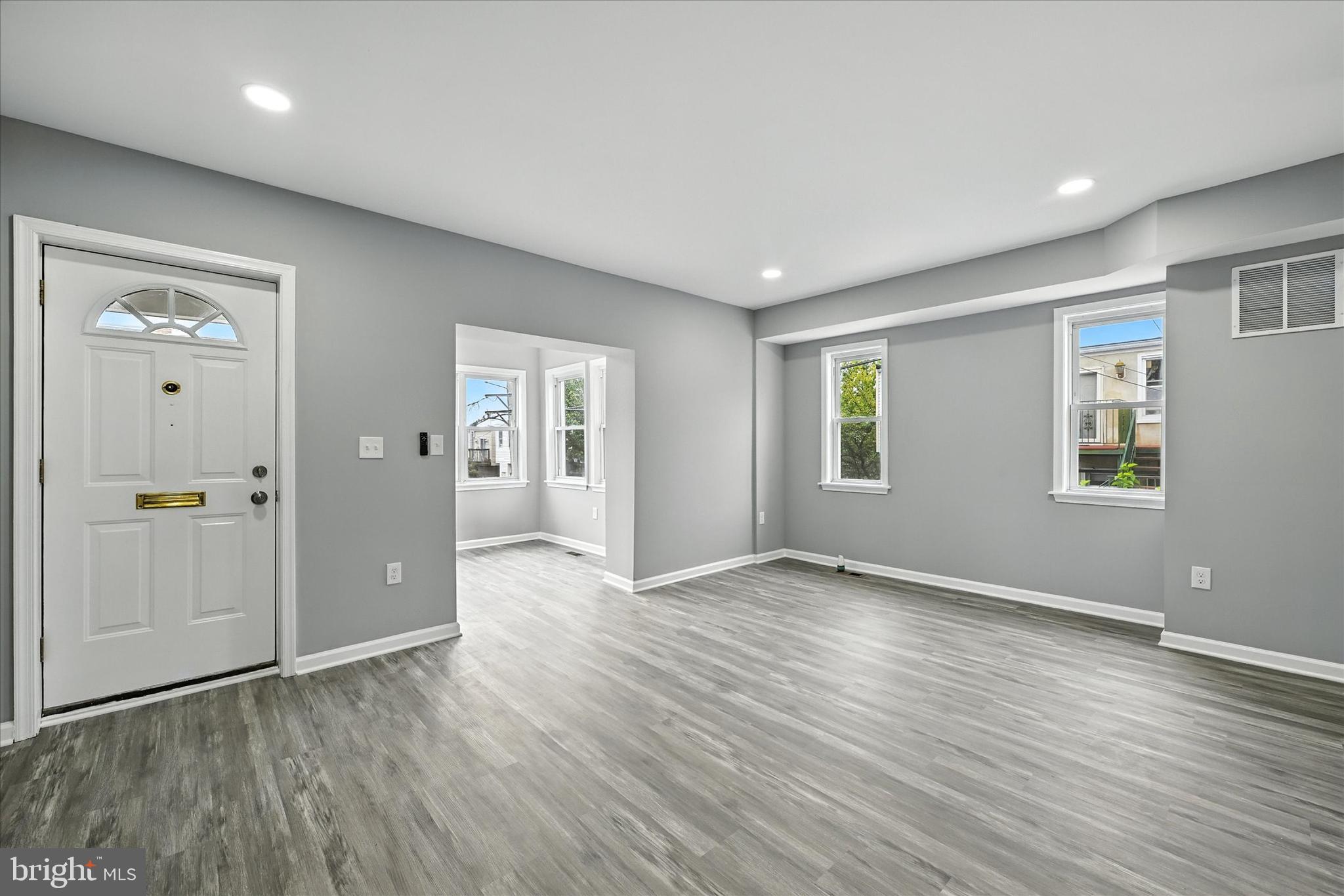 1118 Weldon Avenue Baltimore, MD 21211 - Photo 4 of 27 an empty room with wooden floor and windows