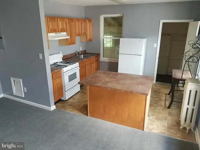 a kitchen with stainless steel appliances kitchen island wooden cabinets and granite counter tops
