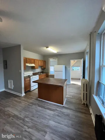 a kitchen with stainless steel appliances granite countertop a stove a sink dishwasher and a refrigerator with wooden floor