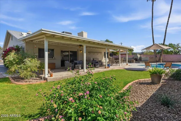 a view of a patio with table and chairs under an umbrella