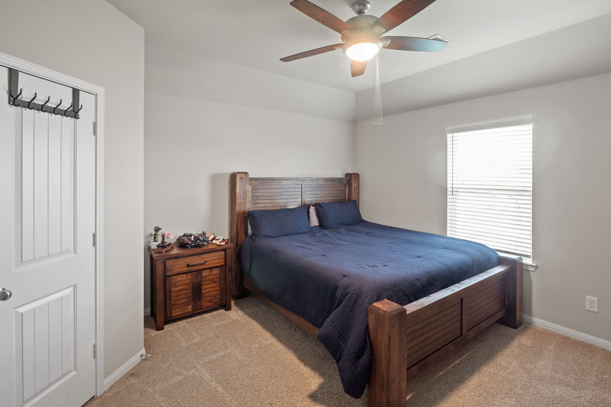 82 Indian Wells Drive Manvel, TX 77578 - Photo 14 of 30 a bed sitting in a bedroom next to a window and a chandelier