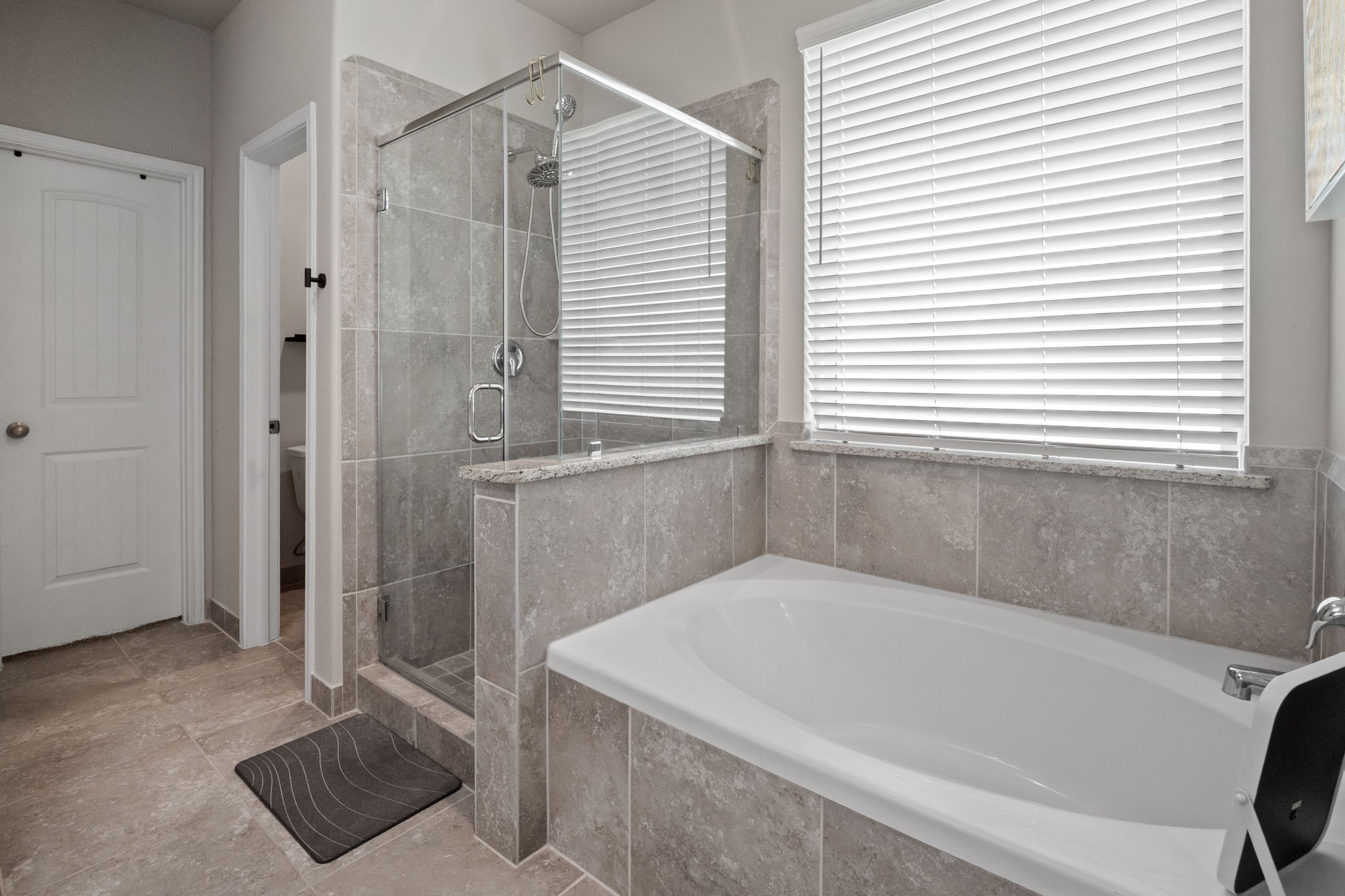82 Indian Wells Drive Manvel, TX 77578 - Photo 16 of 30 a bathroom with a tub a window and a glass door shower