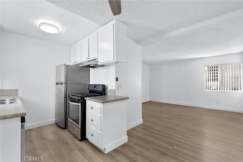 a kitchen with granite countertop a sink stove and refrigerator